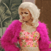 a drag queen is wearing a pink fur coat