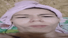 a woman with a towel wrapped around her head is wearing earbuds