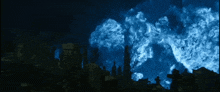 a cemetery at night with a blue light coming out of the sky
