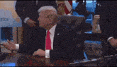 a man in a suit and tie is sitting at a desk with the words " this executive order is the fuck around and find out order "