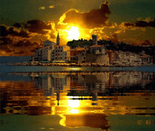 a sunset over a small island with buildings and a clock tower