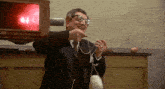 a man with glasses and a ring on his finger is holding a string