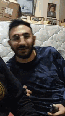 a man wearing glasses is sitting in front of a mattress and a box that says item no. fpm