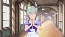 a girl in a blue and white dress is standing in a hallway with her hands folded