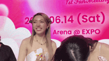 a woman stands in front of a sign that says arena @ expo on it