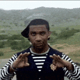 a man wearing a hat and striped shirt is making a funny face .