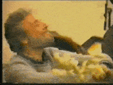 a man with a beard is sitting in a chair with his eyes closed and holding a bouquet of flowers .