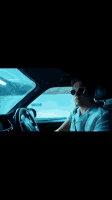 a man wearing sunglasses is sitting in a car