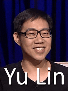a man wearing glasses is smiling in front of a blue curtain and the name yu lin is on the bottom .