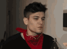 a man wearing a red bandana and holding a bottle of soda .