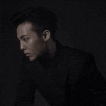 a black and white photo of a young man in a suit and turtleneck