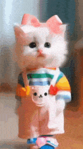 a white cat with a pink bow on its head