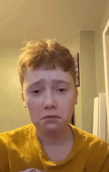 a boy with red hair is wearing a yellow shirt