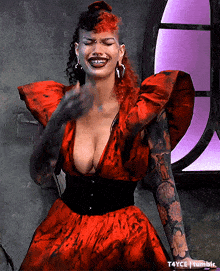 a woman in a red dress with tattoos on her arms