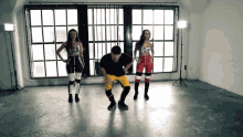 a man and two women are dancing together in a room
