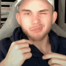 a man with a beard and a hat is making a funny face .