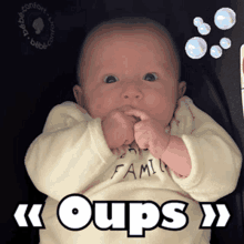 a baby is wearing a shirt that says ' oups ' on it
