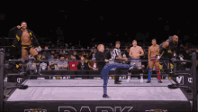a wrestler kicking another wrestler in a ring that says dark on it
