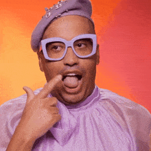 a man wearing glasses and a purple hat covering his mouth