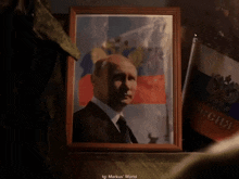 a framed picture of a man in front of a russian flag says markus world