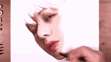 a person is drawing a woman 's face with a brush