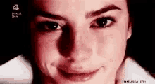 a close up of a woman 's face with a red background and a smile on her face .