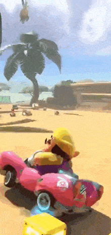 a video game character is driving a pink car in a desert