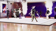 a group of furry animals are dancing on a dance floor