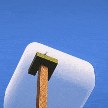 a person standing on top of a wooden pole with a blue sky behind them