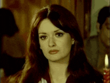 a woman with long hair is looking at the camera