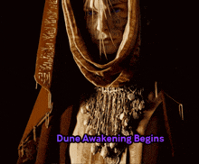 a woman with a scarf around her head and the words dune awakening begins below her