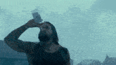 a man is drinking from a glass with a label that says ' a ' on it