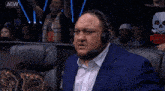a man wearing a headset with the aew logo on the bottom