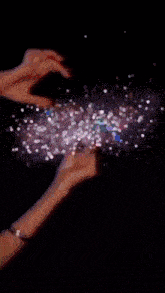a person 's hands are reaching out towards a glowing object