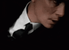 a man in a suit and tie is holding his hand to his face .