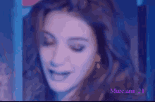 a close up of a woman 's face with the name murciano 21 on the bottom right