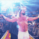a shirtless wrestler with his arms outstretched stands in front of a sign that says wrestlemania