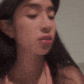 a close up of a woman 's face with her eyes closed . she is wearing a pink bikini top .
