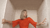 a woman in a red dress is in a white box