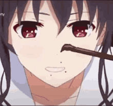 a close up of a girl 's face with a stick in her nose .
