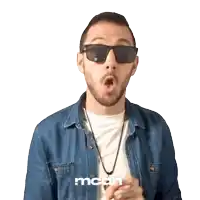a man wearing sunglasses and a denim shirt with the word mcdh on the bottom right