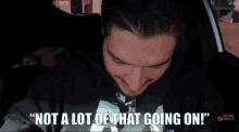 a man in a car with the words " not a lot of that going on " above him