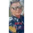 a man wearing sunglasses and a blue shirt is taking a selfie with a cell phone .