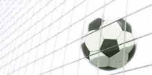a soccer ball is flying through a soccer net .