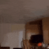 a man wearing an orange hoodie is smiling in a living room .