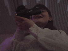 a woman holding a sony 4k camera in her hands