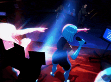 a woman with blue hair singing into a microphone in a dark room