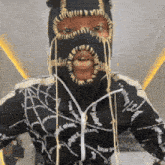 a man wearing a ski mask and a jacket with a spider web pattern on it