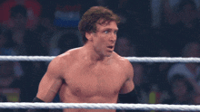 a man without a shirt is standing in a rope ring
