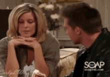 a man and a woman are sitting on a couch and the man is wearing a black jacket .
